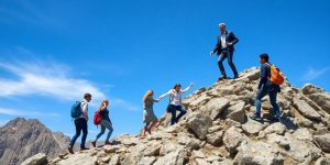 Leader on mountain peak, team climbing.