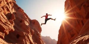 Person leaping canyon, sunlit, vibrant, action, success.